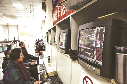 Traders work at a securities exchange house in Shanghai. As Chinau2019s sovereign bond yields tumble to decade-lows, investors are piling into the most defensive part of the stock market in search of returns.