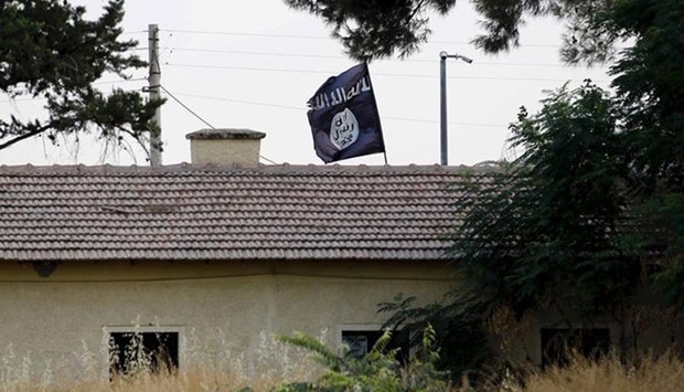 An Islamic State flag flies over the custom office of Syria's Jarablus border gate as it is pictured from the Turkish town of Karkamis, in Gaziantep province, Turkey August 1, 2015. REUTERS