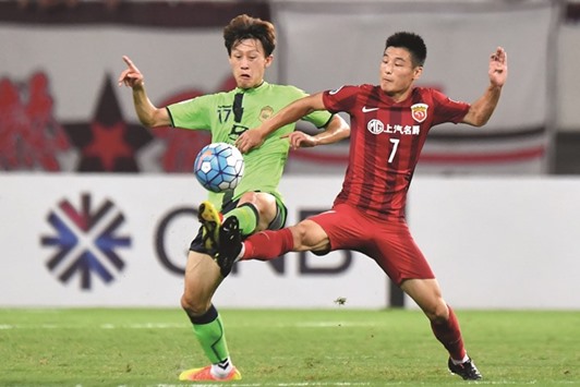 Wu Lei (R) of Chinau2019s Shanghai SIPG fights for the ball with Lee Jae Sung of South Koreau2019s Jeonbuk Hyundai Motors yesterday.
