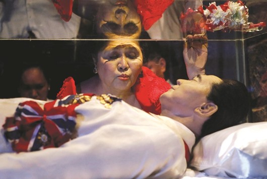 Former first lady Imelda Marcos kisses the glass coffin of her husband, late president Ferdinand Marcos, who remains unburied since his death in 1989, during her 85th birthday celebration in Ferdinand Marcosu2019 hometown of Batac, Ilocos Norte province, in northern Philippines July 2, 2014.