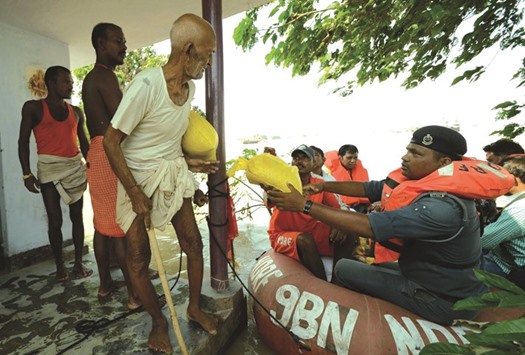 NDRF personnel distribute food packets to flood victims in Danapur near Patna.