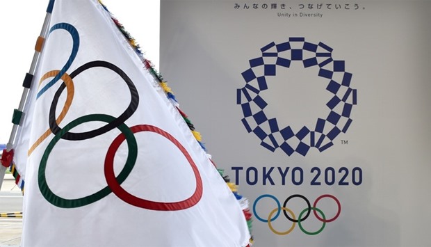 The Olympic flag (L) and the logo of the Tokyo 2020 are displayed during the official flag arrival ceremony