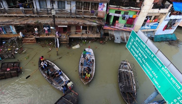 Indian flood-affected residents use boats as they attempt to shift to dry ground