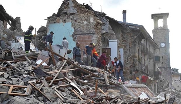 Rescuers work at a collapsed building following an earthquake in Amatrice on Wednesday.