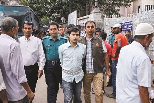 Bangladeshi security personnel escort Sifat (centre), who also goes by the aliases Shamim and Moinul Islam towards a court in Dhaka yesterday.