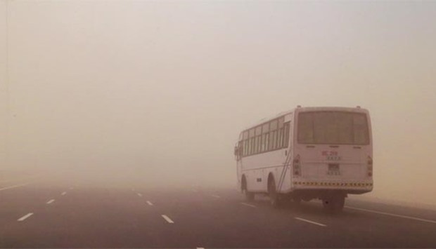 A bus making its way through the dust storm on the Sheehaniyah road. PICTURE: Jayan Orma.