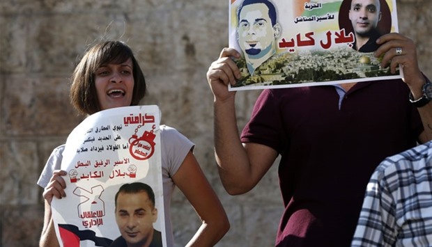Palestinian protestors hold posters during a demonstration against administrative detention and in support of Palestinian prisoner Bilal Kayed (portraits) on August 24, 2016 at Damascus Gate, a main entrance to Jerusalem's Old City.