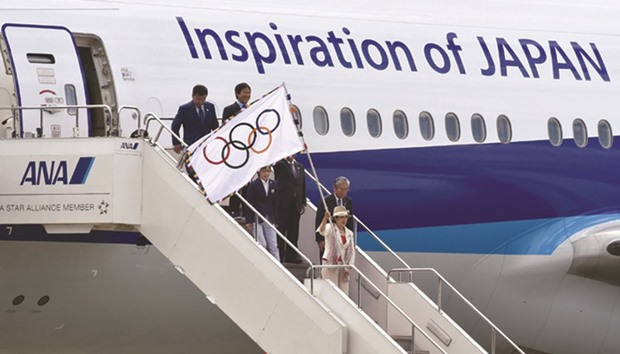 Tokyo governor Yuriko Koike (R) holds the Olympic flag as she arrives at the Tokyou2019s Haneda airport yesterday.
