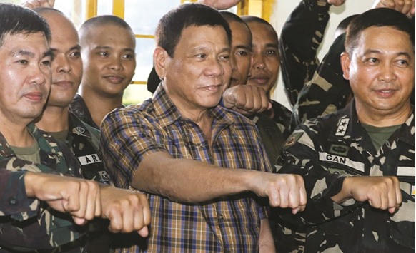 Philippine President Rodrigo Duterte makes a u201cfist bumpu201d, his May presidential elections campaign gesture, with soldiers during a visit at Capinpin military camp in Tanay, Rizal in the Philippines yesterday.