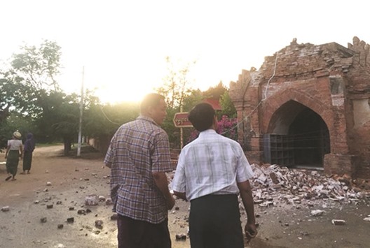 Two men look at a collapsed entrance of a pagoda after an earthquake in Bagan, Myanmar, yesterday