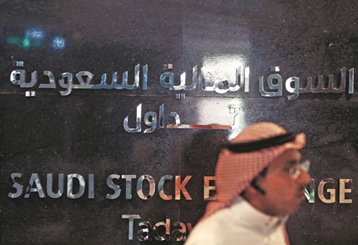 A trader monitors stock information at the Saudi Stock Exchange (Tadawul) in Riyadh. The Saudi index, which on Wednesday fell below minor technical support on the April low of 6,066 points, dropped 0.9% yesterday to a six-month closing low of 5,977 points.