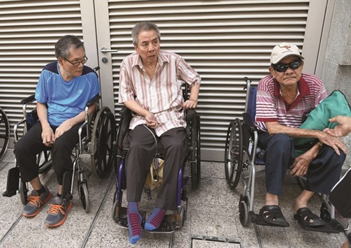 Singaporeans from the St Joseph Home for The Elderly wait for their transport after paying their final respects to the late former president S R Nathan as he lay in state in Singapore yesterday.