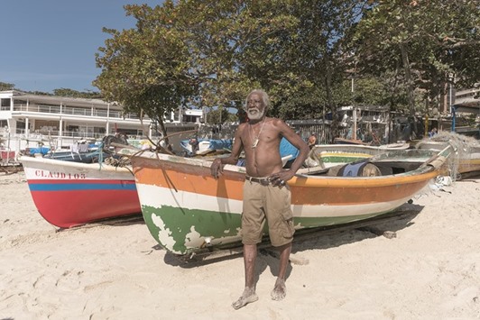 Fisherman Josu00e9 de Jesus Damasceno, nicknamed Caco, stands on a beach in Rio.