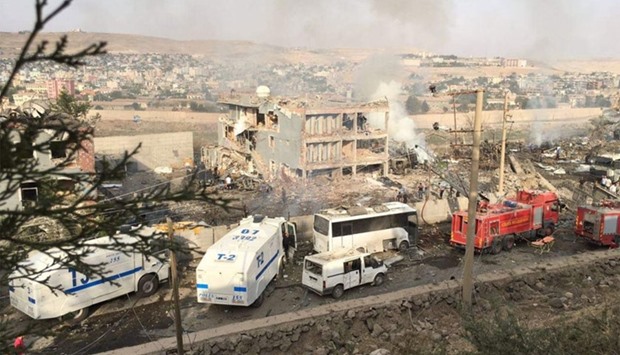 Turkish police and firefighters are parked near a damaged police headquarters after a car bomb killed 11 and wounded dozens in Cizre, southeastern Turkey.