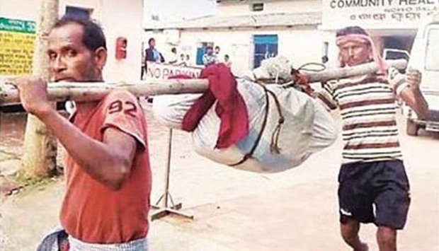 Hospital workers carry the body of a woman in Odisha state. 