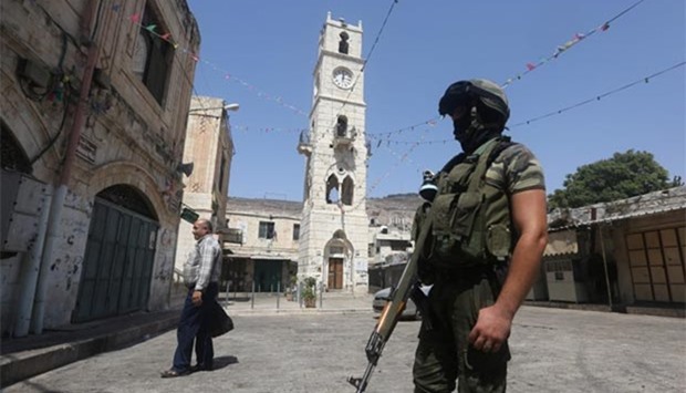 A member of the Palestinian security forces stands guard in the the old part of the West Bank city of Nablus on Friday during an ongoing operation to arrest wanted Palestinian gunmen.