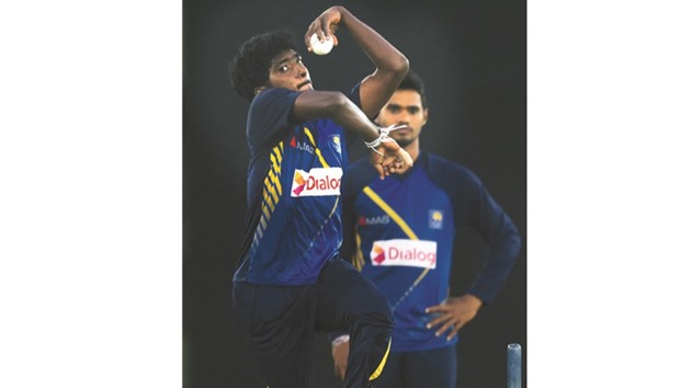 Sri Lankau2019s Lakshan Sandakan (L) delivers a ball as teammate Dhananjaya de Silva looks on during a practice session at the Rangiri Dambulla International Cricket stadium in Dambulla yesterday.