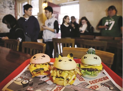 GOTTA EAT THEM ALL! People line up to buy u2018Pokeburgsu2019 at Down Nu2019 Out Burger restaurant in Sydney yesterday.