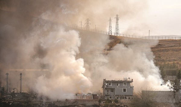 Smoke rises from damaged police headquarters after the suicide truck bombing in Cizre.