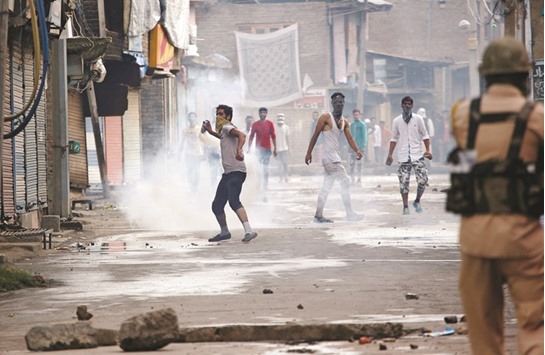A protester throws back a teargas shell fired by the Indian police during a protest in Srinagar.