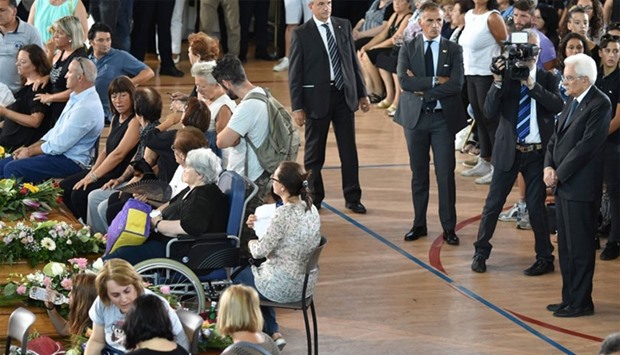 Italy's President Sergio Mattarella (R) attends a funeral service for victims of the earthquake, at a gymnasium arranged in a chapel of rest on August 27, 2016, in Ascoli Piceno, three days after a 6.2-magnitude earthquake struck the region killing some 281 people.