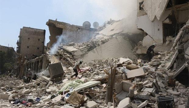 Syrian rescue workers search for victims through the rubble of a building destroyed during a reported barrel bomb attack