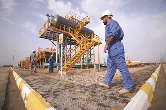 Iraqi labourers work at an oil refinery in the southern town Nasiriyah. Opecu2019s second-largest producer, trailing Saudi Arabia, Iraq depends on oil sales for 95% of its public spending. Its economy is reeling under the double impact of low oil prices and the rising cost of the war on Islamic State militants.