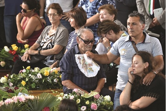 People attend a funeral service for victims of the earthquake, at a gymnasium arranged in a chapel of rest yesterday in Ascoli Piceno.
