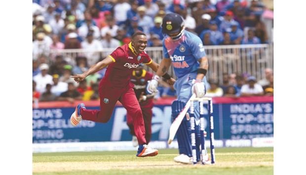 Dwayne Bravo (L) of the West Indies celebrates the dismissal of Virat Kohli (R) of India during their T20 international yesterday at Central  Broward Stadium in Fort Lauderdale, Florida.