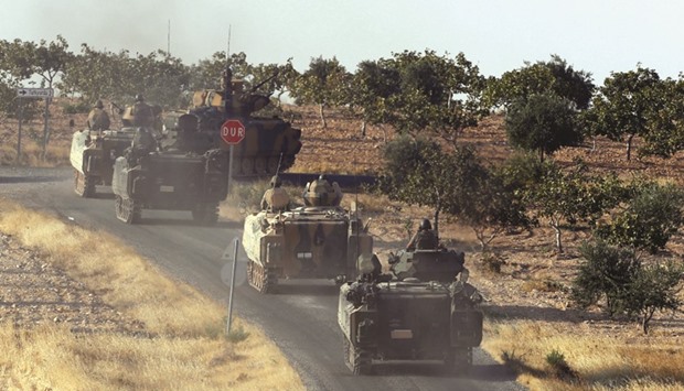 Turkish armoured personnel carriers driving towards the border in Karkamis in the southeastern Gaziantep province yesterday.
