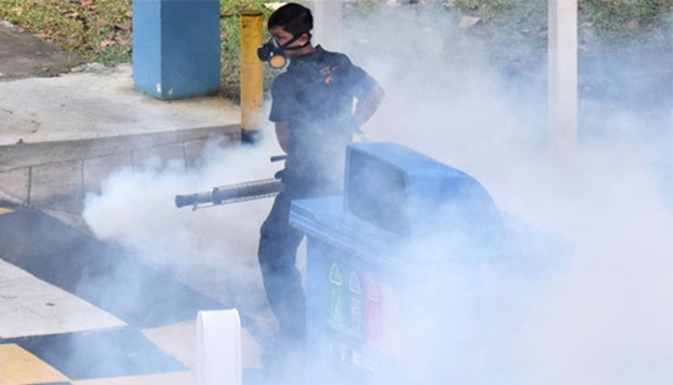 Singapore on April 5, 2016 shows a worker fumigating an area against mosquitoes