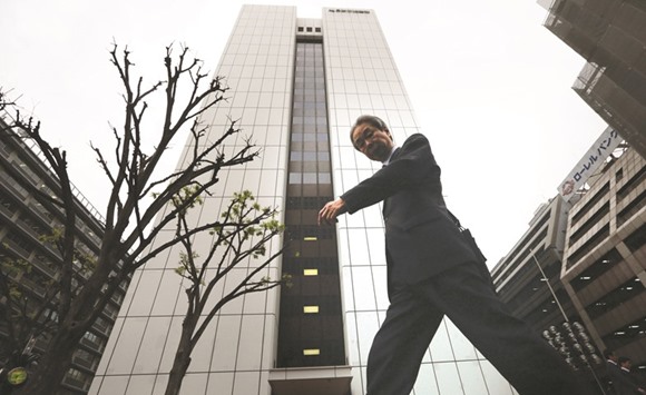 A pedestrian walks past the building housing the Government Pension Investment Fund headquarters in Tokyo. GPIF makes the top 10 list in all but seven companies in the Topix 500 Index of Japanu2019s largest firms, calculated based on outstanding shares this month and assuming the fundu2019s investments havenu2019t changed.