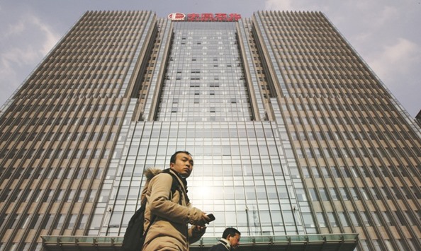 Pedestrians walk past the China Petroleum & Chemical Corp (Sinopec) headquarters in Beijing. The worldu2019s biggest oil refiner posted a 22% decline in profit for the first half of the year as oilu2019s collapse overpowered the boost from cheaper crude used to make fuels and chemicals.