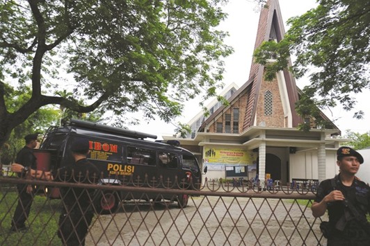 Police are seen outside Saint Joseph catholic church after a suspected terror attack by a knife-wielding assailant on a priest during the Sunday service in Medan, North Sumatra.