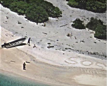 This image obtained courtesy of the US Navy shows the couple signalling for help with an u2018SOSu2019 written in the sand on East Fayu Island, Micronesia.