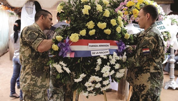 Paraguayan soldiers present a wreath at the wake of fellow soldier Pablo Farias, one of the eight soldiers killed in an ambush, in Loreto city.