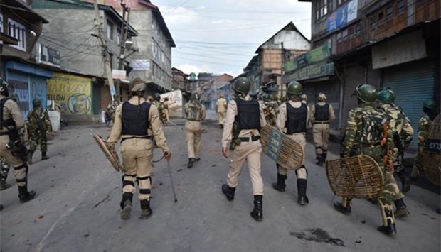 Security forces chase Kashmiri protesters during clashes in Srinagar on Monday.