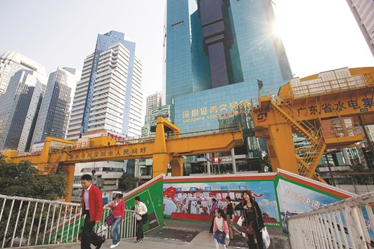 People walk in front of the Shenzhen Stock Exchange building in China. Exchanges in Shenzhen and Shanghai have opened 774 investigations into wild price swings since the start of July and halted 38 investor accounts, according to the two boursesu2019 official micro-blogs.
