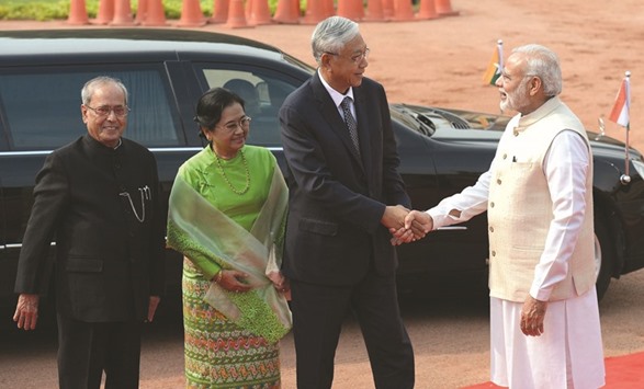 Prime Minister Narendra Modi shakes hands with Myanmar President U Htin Kyaw as his wife Daw Su Su Lwi and President Pranab Mukherjee look on during a ceremonial reception in New Delhi yesterday.