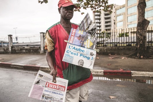 A newspaper vendor looks for customers in Libreville while displaying local papers reporting on the outcome of Gabonu2019s presidential elections.