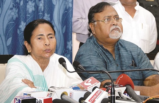 West Bengal Chief Minister Mamata Banerjee addresses a press conference at the State Assembly in Kolkata as state Education Minister Partha Chatterjee looks on.