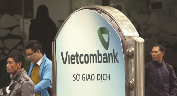 Employees walk out of a branch office of Vietcombank in Hanoi. Singapore sovereign wealth fund GIC yesterday signed a memorandum of agreement to buy 305.8mn new shares of Vietnamese commercial bank.