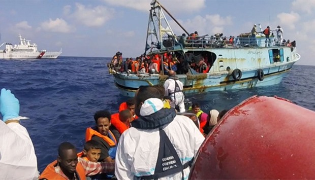 Italian coast guard personnel taking part in a rescue operation of a boat with migrants