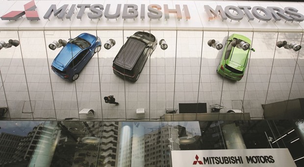 Mitsubishi Motorsu2019 vehicles are reflected on an external wall at its headquarters in Tokyo. Japanu2019s transport ministry said its investigation had shown the automaker had overstated the fuel economy for eight vehicles including the RVR, Pajero and Outlander SUV models, in addition to four minivehicles initially confirmed in April.