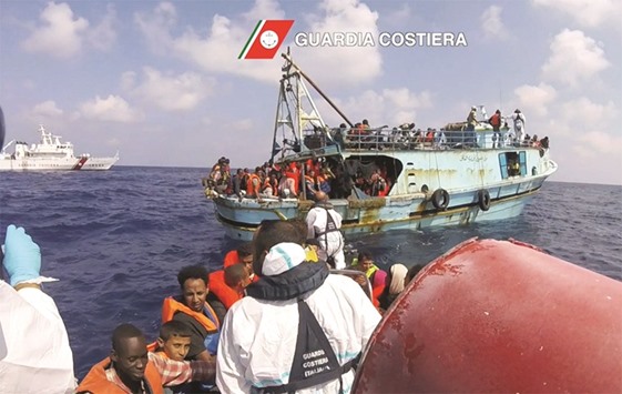 This image grab taken from a handout video and released by the Italian Coast Guard (Guardia Costiera) yesterday, shows Italian coast guard personnel taking part in a rescue operation of a boat with migrants in the Mediterranean Sea. Around 6,500 migrants were rescued off the coast of Libya on Monday.