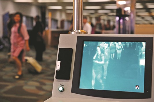 Airplane passengers walk through the feverscan camera system used to detect human temperature shortly after arriving from Singapore at the Soekarno-Hatta airport in Jakarta, Indonesia yesterday.