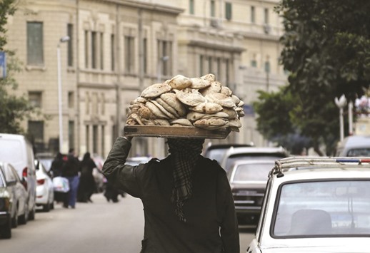 A man carries freshly baked bread on his head along a street in Cairo. Egypt, which is central to the wheat market because it buys grain to subsidise bread for more than 90mn citizens, has caused upheaval in the market before.