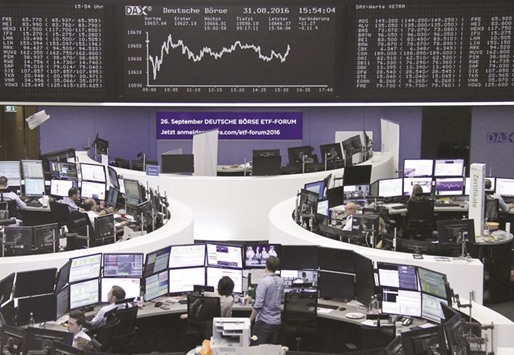 Traders work at their desks in front of the DAX board at the Frankfurt Stock Exchange yesterday. DAX 30 ended the day up 1.1% at 10,657.64 points.