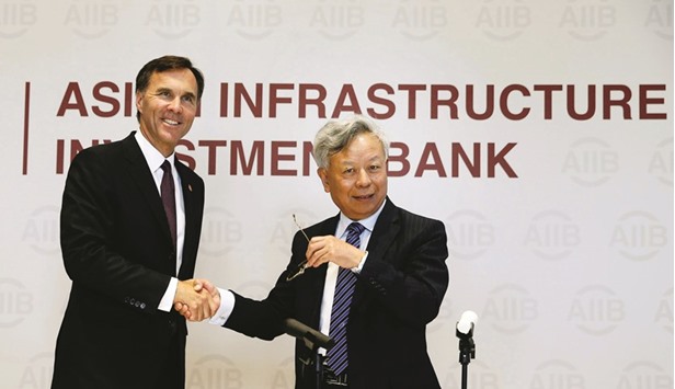 Asian Infrastructure Investment Bank president Jin Liqun (right) and Canadau2019s Finance Minister Bill Morneau attend a news conference in Beijing yesterday. Joining the  China-backed AIIB would create jobs and business opportunities for Canadians, Morneau said, adding: Participation in the bank is clearly in Canadau2019s best interest.