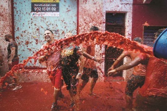 Revellers covered in tomato pulp participate in the annual u201ctomatinau201d festivities in the village of Bunol yesterday.
